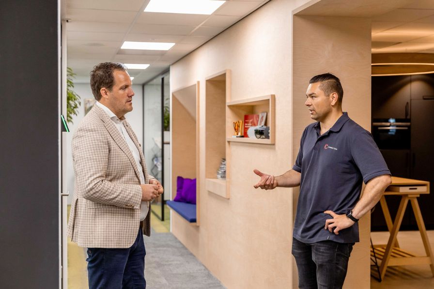 Roy en Herwin in overleg bij de werkplek 
